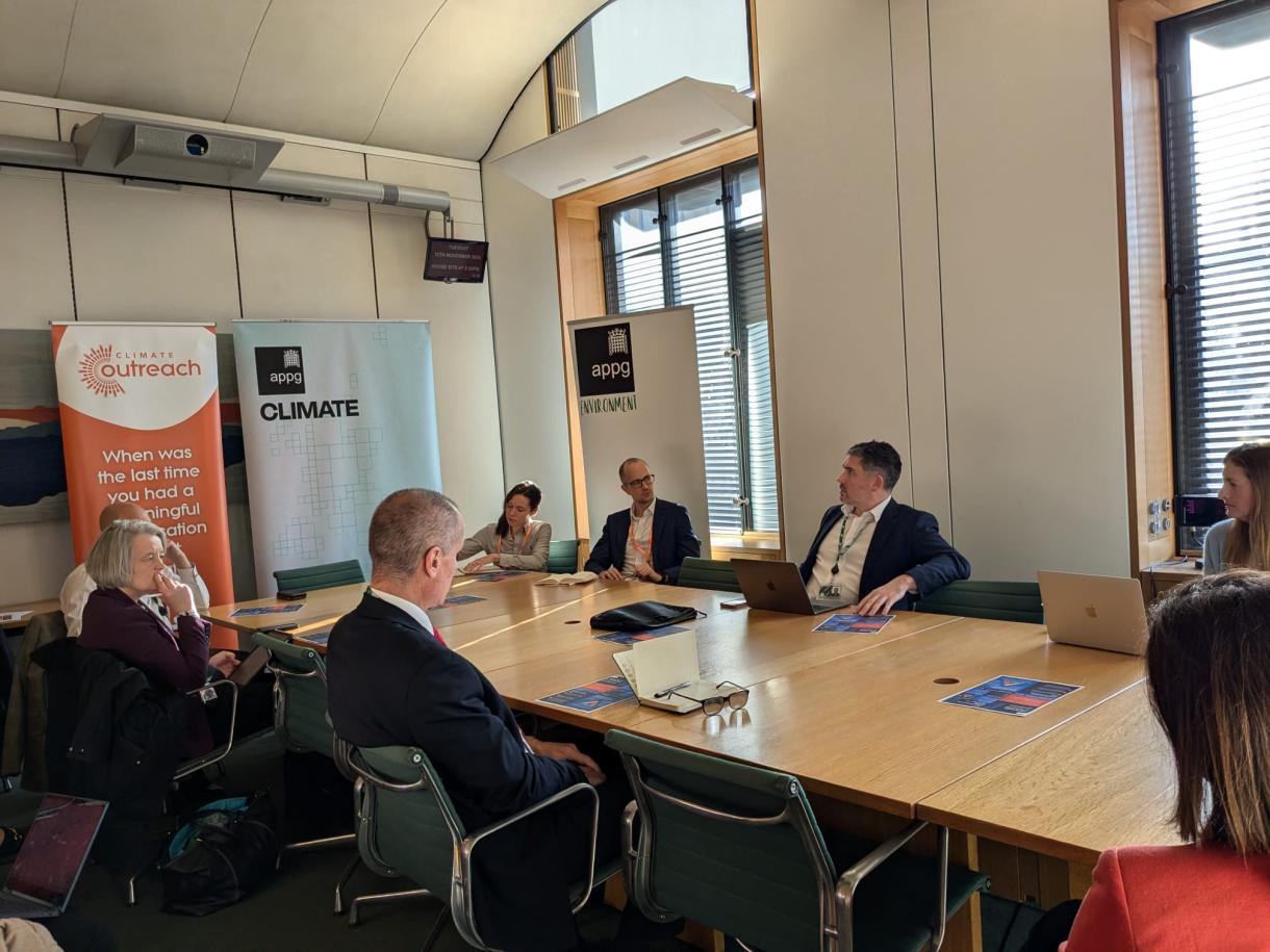 MPs sit and discuss around a table