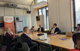 MPs sit and discuss around a table