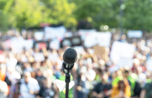 Image of microphone in front of a crowd